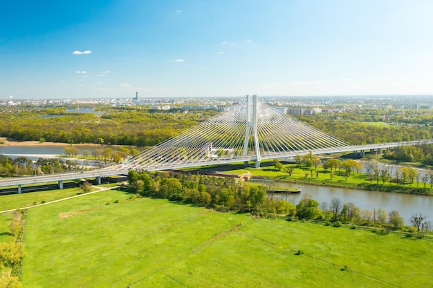 Le auto percorrono il ponte strallato Redzinski sul fiume che scorre vicino al pittoresco ponte dei piloni di Wroclaw