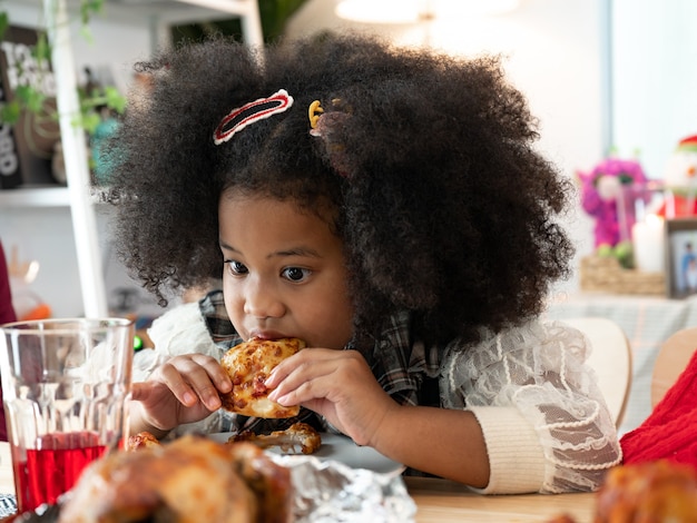 Le bambine felici con i capelli afro mangiano cibo