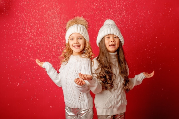 Le bambine prendono la neve su uno sfondo rosso