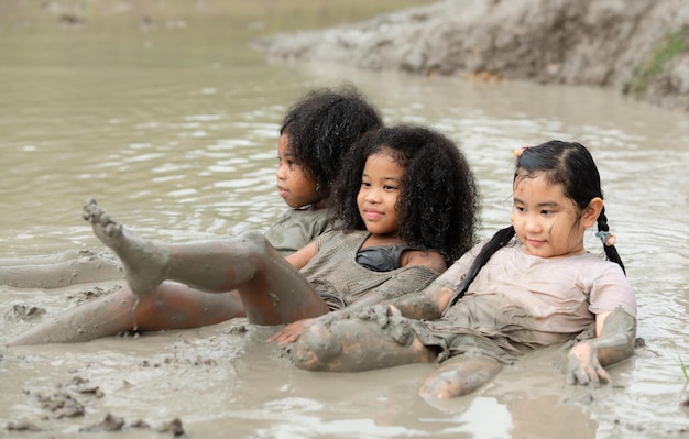 Le bambine si divertono a giocare nel fango nei campi della comunità.