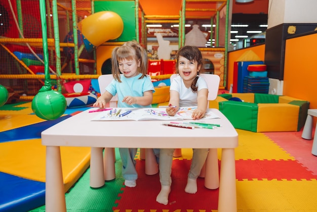 Le bambine sono sedute a un tavolo e disegnano in un centro giochi per bambini la creatività dei bambini