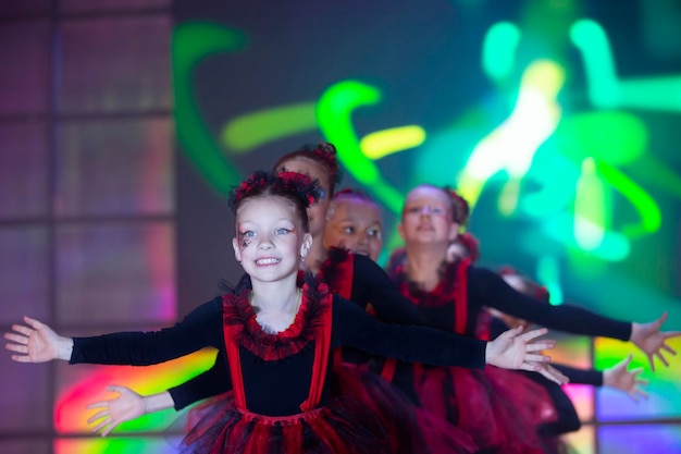 Le bambine stanno eseguendo un numero di danza Dance for Helovinna in abiti rossi