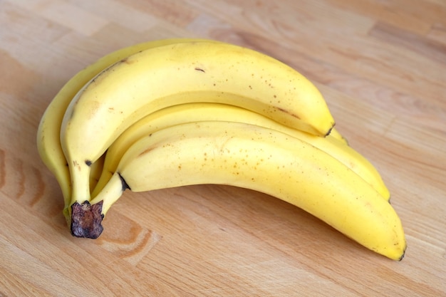 Le banane mature si trova sul primo piano reale della foto di vista orizzontale della tavola di legno marrone