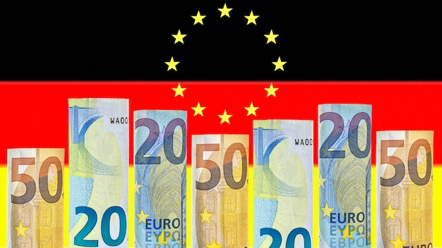 Le banconote in euro arrotolate in un tubo sullo sfondo della bandiera della Germania