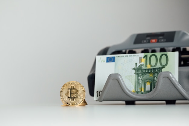 Le banconote in euro e il concetto di investimento in criptovaluta Bitcoin. Moneta dorata del bitcoin di valuta di Euro Money e Crypto.