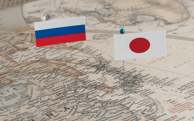 Le bandiere della Russia e del Giappone sulla mappa del mondo Differenze politiche dovute all'isola di Sakhalin