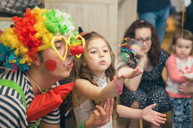 Le bolle di sapone mostrano i pagliacci alla festa dei bambini