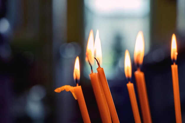 Le candele stanno bruciando nella chiesa su uno sfondo scuro