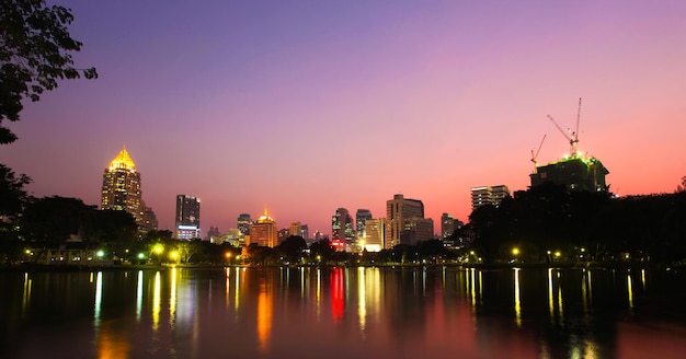 Le case e le luci della città moderna si riflettono nell'acqua al tramonto