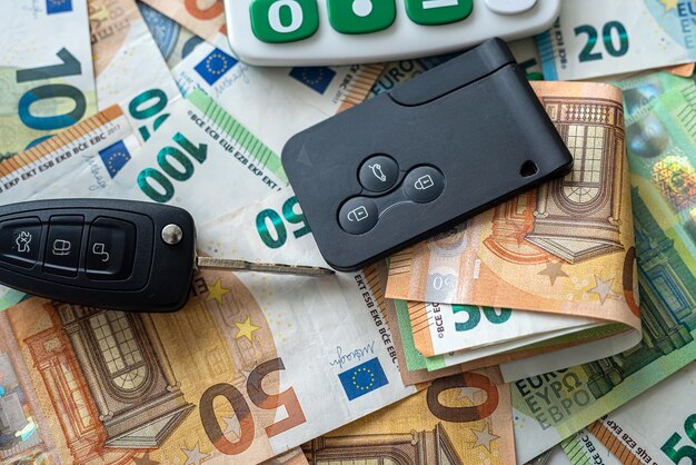 Le chiavi dell'auto nere giacciono sulle banconote in euro Concetto di vendita o assicurazione di noleggio auto di ricchezza