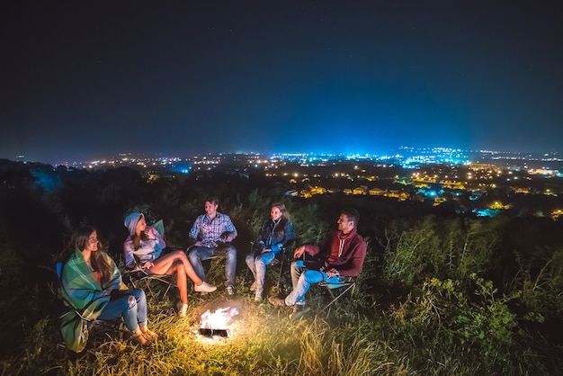 Le cinque persone riposano vicino al falò. sera notte