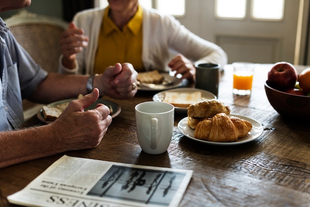 Le coppie adulte senior mangiano la prima colazione