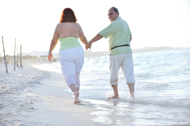 le coppie anziane mature anziane felici hanno tempo romantico sulla spiaggia al tramonto