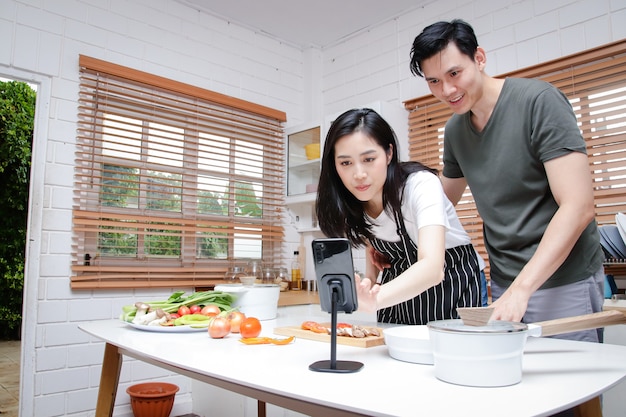 Le coppie asiatiche hanno la gioia di cucinare in cucina a casa