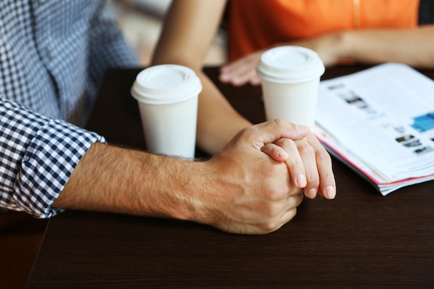 Le coppie bevono il caffè in primo piano all'aperto del caffè