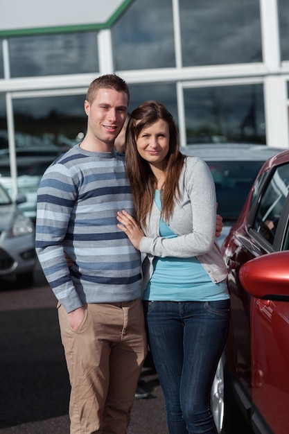 Le coppie che tengono stretto mentre stanno accanto ad un&#39;automobile