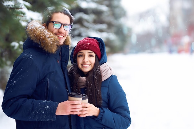 Le coppie felici con caffè nella foresta invernale fanno selfie. . Felice periodo invernale. Natale.