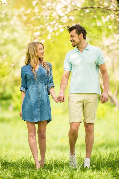 Le coppie hanno vestito casuale divertendosi nel parco dell&#39;estate.