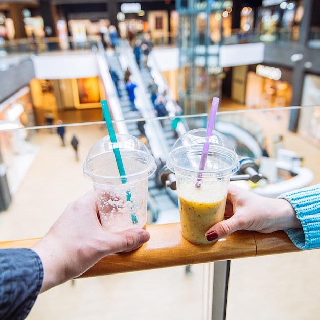 Le coppie nel centro commerciale fanno il concetto di stile di vita dei frullati della bevanda dello shopping