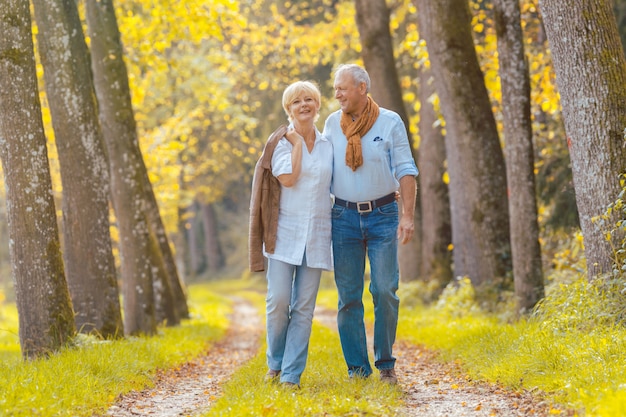 Le coppie senior che hanno svago camminano in legno