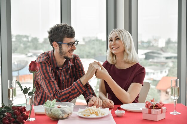 Le coppie si tengono per mano e propongono il matrimonio sul tavolo