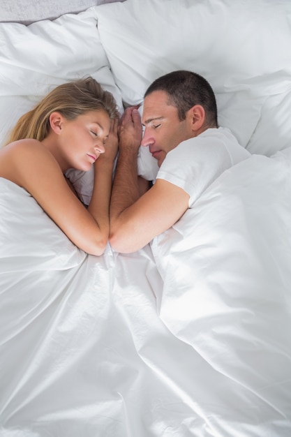 Le coppie sveglie che si trovano a letto addormentato nel colpo sopraelevato a casa in camera da letto
