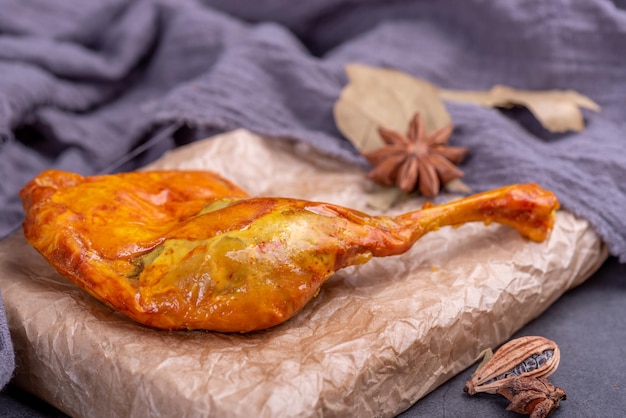 Le cosce di pollo gialle marinate nel contenitore sono su uno sfondo scuro