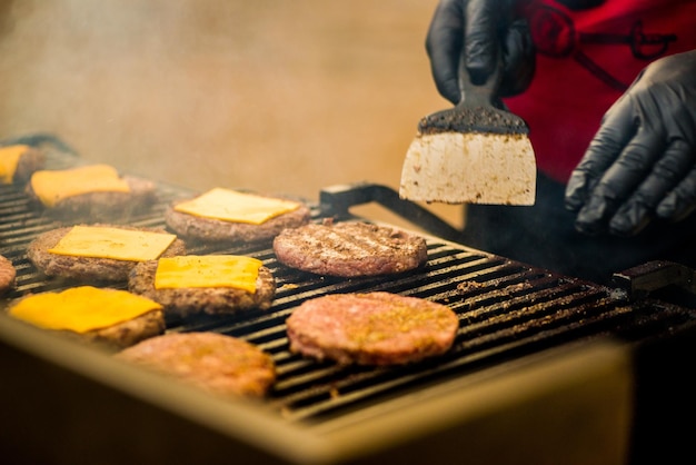 Le cotolette di hamburger sono grigliate. Picnic con hamburger. Griglia a carbone