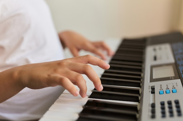 Le dita di un bambino che suonano il pianoforte