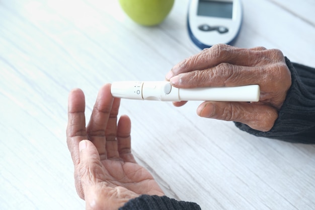 Le donne anziane diabetiche misurano il livello di glucosio a casa