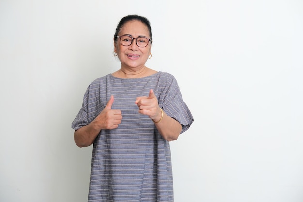 Le donne asiatiche anziane che puntano il dito in avanti e danno il pollice in su