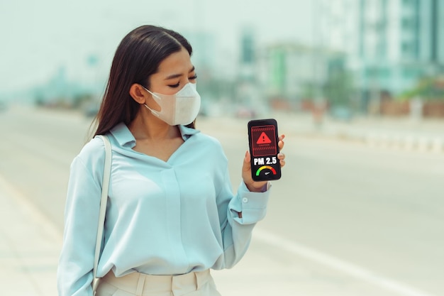 Le donne asiatiche che indossano la maschera di protezione sentono mal di testa e tosse a causa dell'inquinamento atmosferico PM 25 L'inquinamento atmosferico ha causato problemi di salute inquinamento ambientale