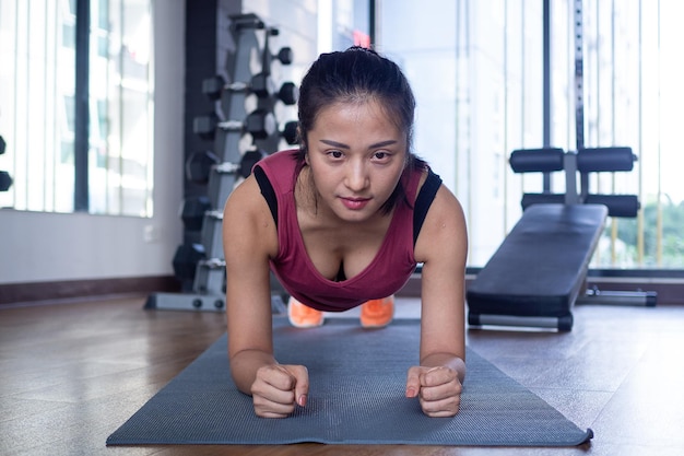 Le donne asiatiche esercitano il fasciame su stuoie sul pavimento della palestra Le donne forti si esercitano per una buona salute Il concetto di donne fitness