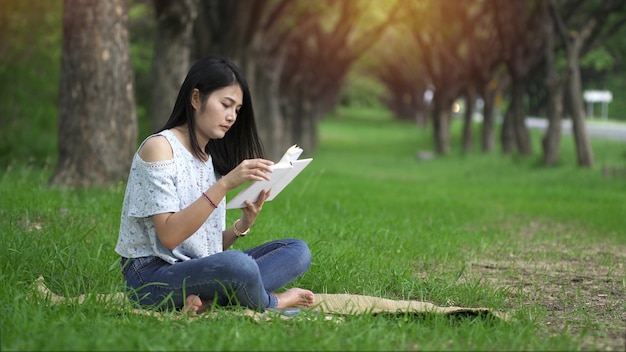 Le donne asiatiche leggono felicemente i libri al parco