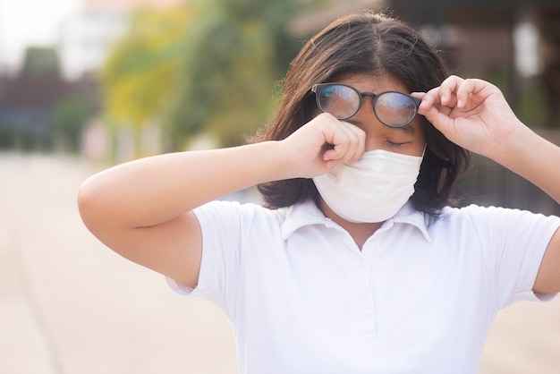 Le donne asiatiche si grattano le palpebre a causa di un'allergia all'aperto. La femmina ha prurito agli occhi