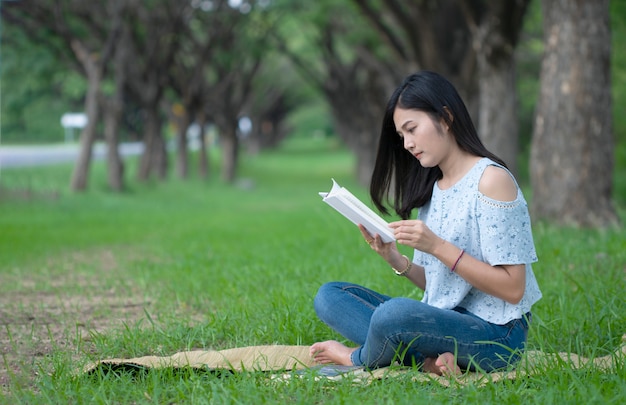 Le donne asiatiche si siedono a leggere al parco