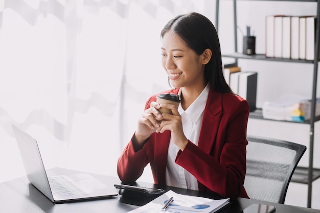 Le donne asiatiche sono stressate mentre lavorano sul laptop Donna d'affari asiatica stanca con mal di testa in ufficio che si sente male al lavoro spazio di copia