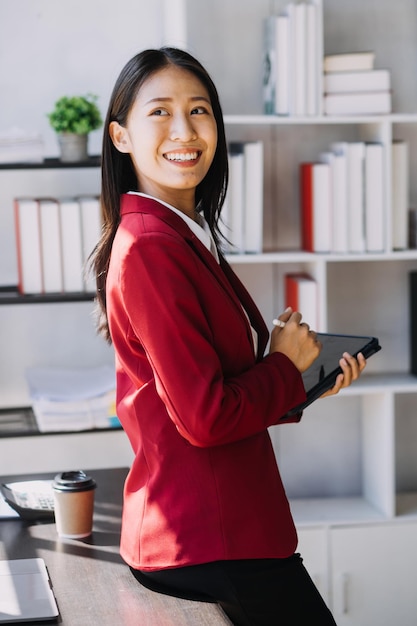 Le donne asiatiche sono stressate mentre lavorano sul laptop Donna d'affari asiatica stanca con mal di testa in ufficio che si sente male al lavoro spazio di copia