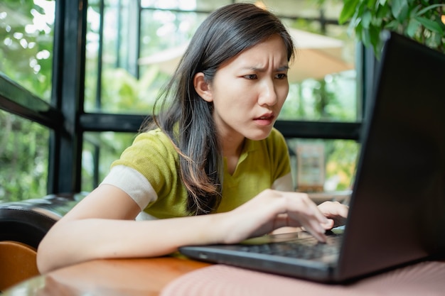 Le donne asiatiche usano i loro laptop per lavorare nel caffè