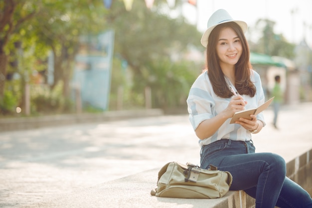 Le donne asiatiche viaggiano rilassandosi in vacanza. Scrivete una nota.