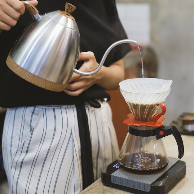 Le donne barista versano acqua per fare il caffè usando un infusore manuale a goccia Caffè a goccia a mano