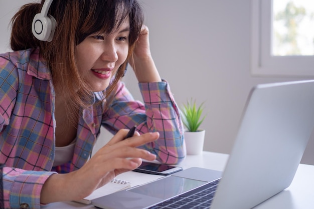 Le donne che lavorano o studiano a casa utilizzano la comunicazione in videoconferenza con un auricolare