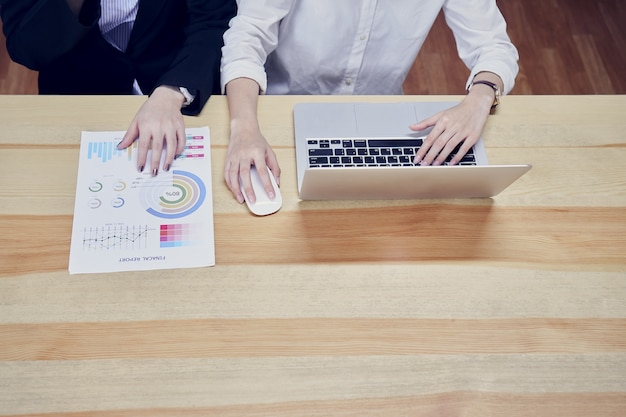 Le donne d&#39;affari usano laptop e documenti finanziari per lavorare in ufficio.