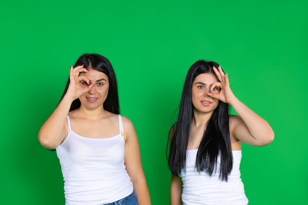 Le donne gemelle mostrano che va tutto bene sorridendo carine