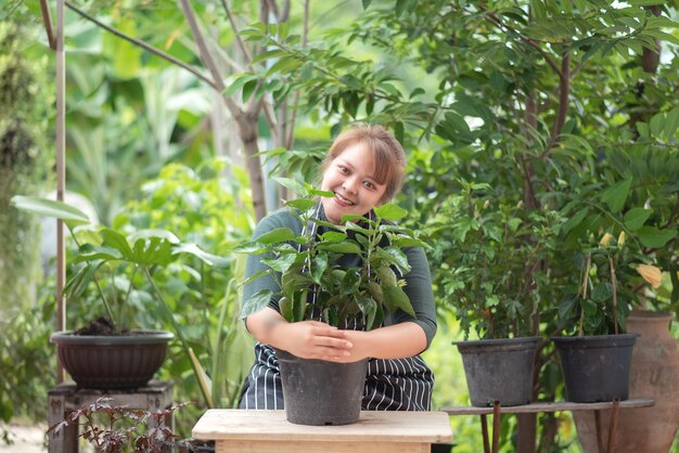 Le donne giardiniere vendono alberi sui social media. Concetto di acquisto e vendita online.