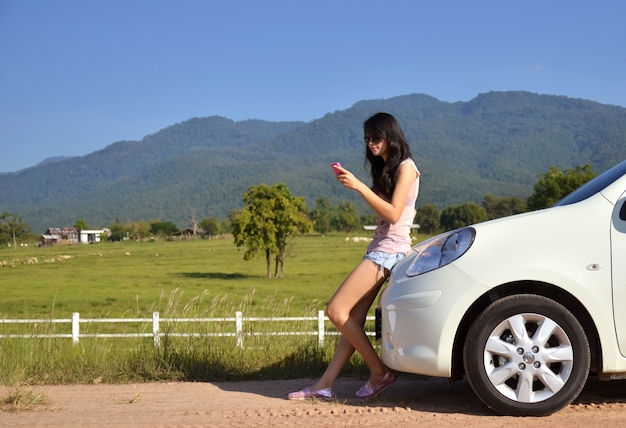 le donne graziose usano il suo telefono nel paese