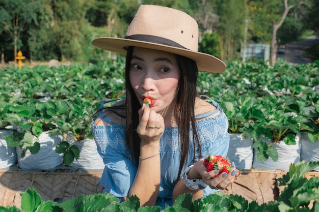 Le donne mangiano fragole nel fruttivendolo.