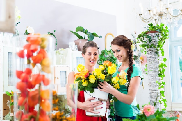 Le donne nel negozio di fiori si godono le rose