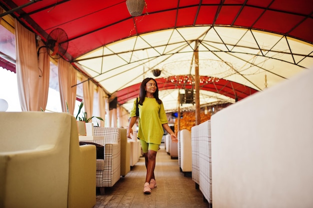 Le donne nere indossano abiti estivi verdi posano nel bar della tenda. Ragazza afroamericana.