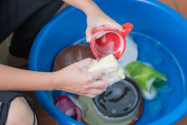 le donne passano usando una spugna gialla per lavare il bicchiere